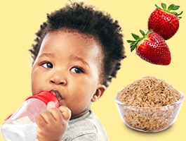 Un bebé con un sippy cup junto a fresas y un tazón con cereal.