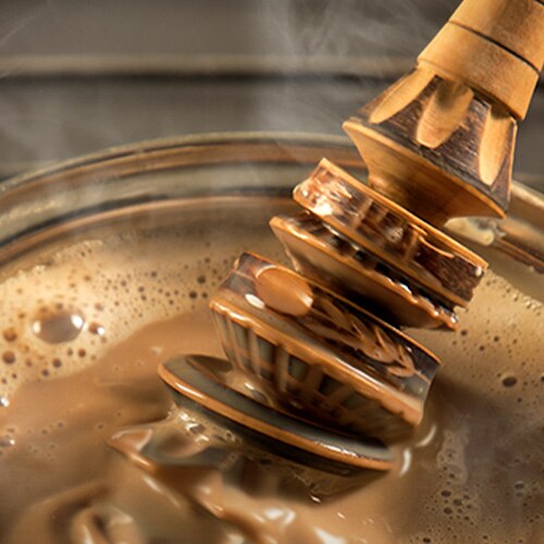 Un molinillo bate un humeante chocolate caliente.