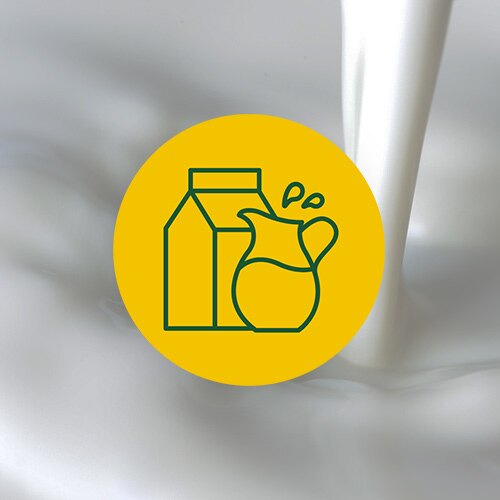 Un círculo color amarillo con una ilustración de un envase de leche y una jarra sobre una imagen de leche vertiéndose.